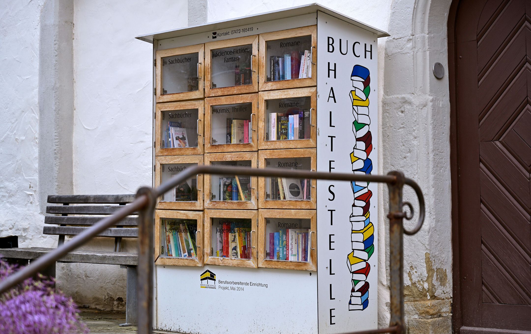 Ein alter Holzschrank mit Büchern darin.