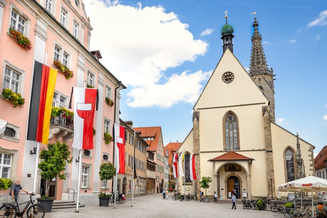 Blick auf den Marktplatz von Rottenburg. Links im Bild das Rathaus mit Fahnenmasten und gehissten Fahnen