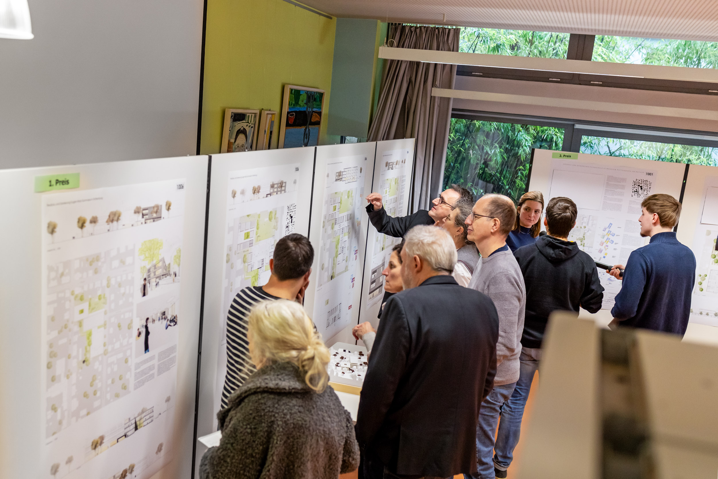 Mehrere Personen betrachten die Architekturentwürfe