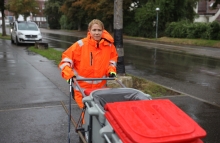 Frau Schwieren schiebt einen Müllwagen