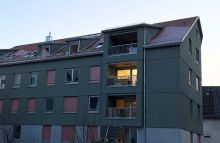 Mehrfamilienhaus von außen in der Abenddämmerung