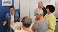 Diskussionsrunde einiger Senior*innen an einem Stehtisch 