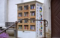 Ein alter Holzschrank mit Büchern darin. 