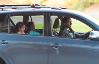 Ein Mann und zwei Kinder im Auto. Seitliche Ansicht von außen. 