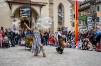 2 Künstler auf dem Marktplatz und viele Zuschauer im Kreis drumherum 