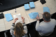 Zwei Personen öffnen Briefwahlunterlagen 