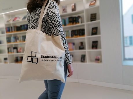 Eine Frau trägt über der Schulter eine Stofftasche mit der Aufschrift 