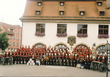 Große Gruppe von Uniformierten vor historischem Gebäude