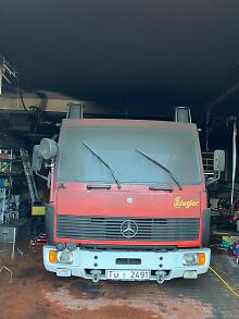 Verrauchtes Feuerwehrhaus mit Auto darin