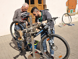 Zwei Menschen reparieren ein Fahrrad