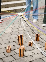Schüler führen auf dem Pausenhof ein Experiment mit Schnüren und Feuer durch.