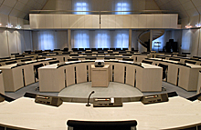Sitzungssaal mit kreisförmig angeordneten Sitzen und Empore